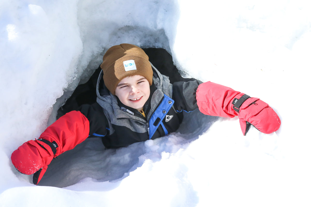 Child wearing L-Bow mittens outside in the snow